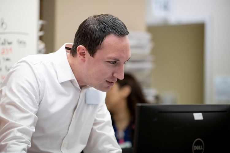 Doctor looking at computer monitor.