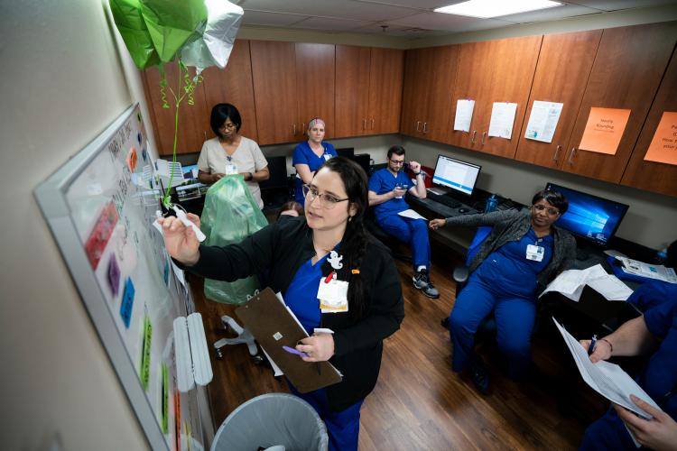 Nurses gather as they get ready to do a shift change hand-off at JPS Health Network in Fort Worth, Texas