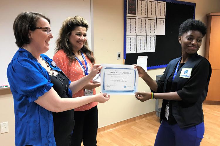 Volunteer Christina Lulenda receives a certificate of completion.