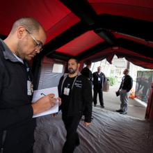 JPS Emergency Management team members inspect a COVID-19 screening tent.